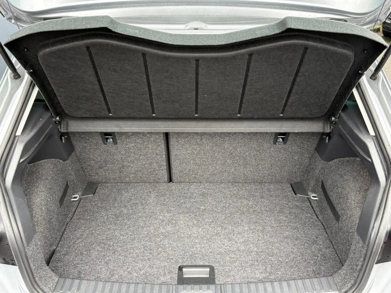 Coffre ouvert vu de l'arrière d'une SEAT Ibiza 2024 argent urbain, montrant un espace de rangement propre et spacieux.