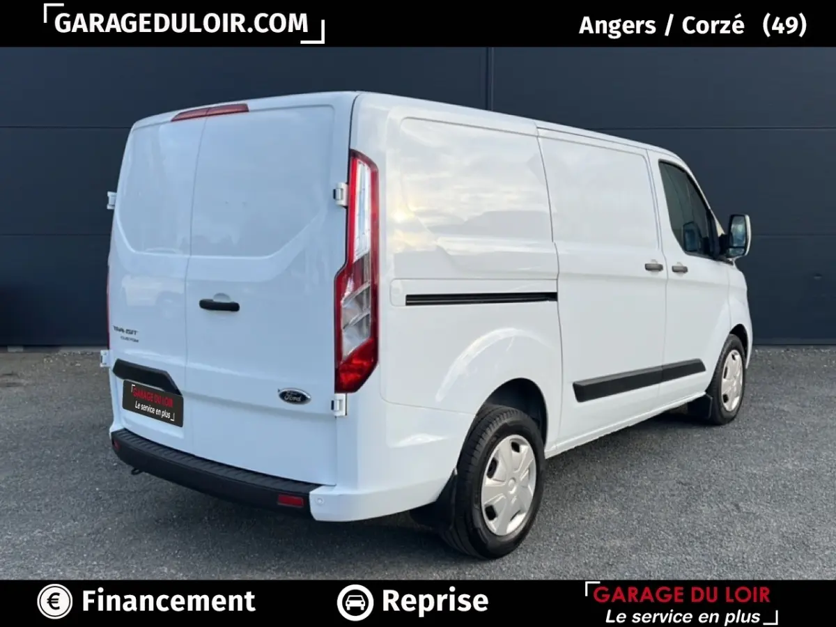 Vue 3/4 arrière droite d’un Ford Transit Custom Fourgon blanc avec feux arrière verticaux et jantes acier.