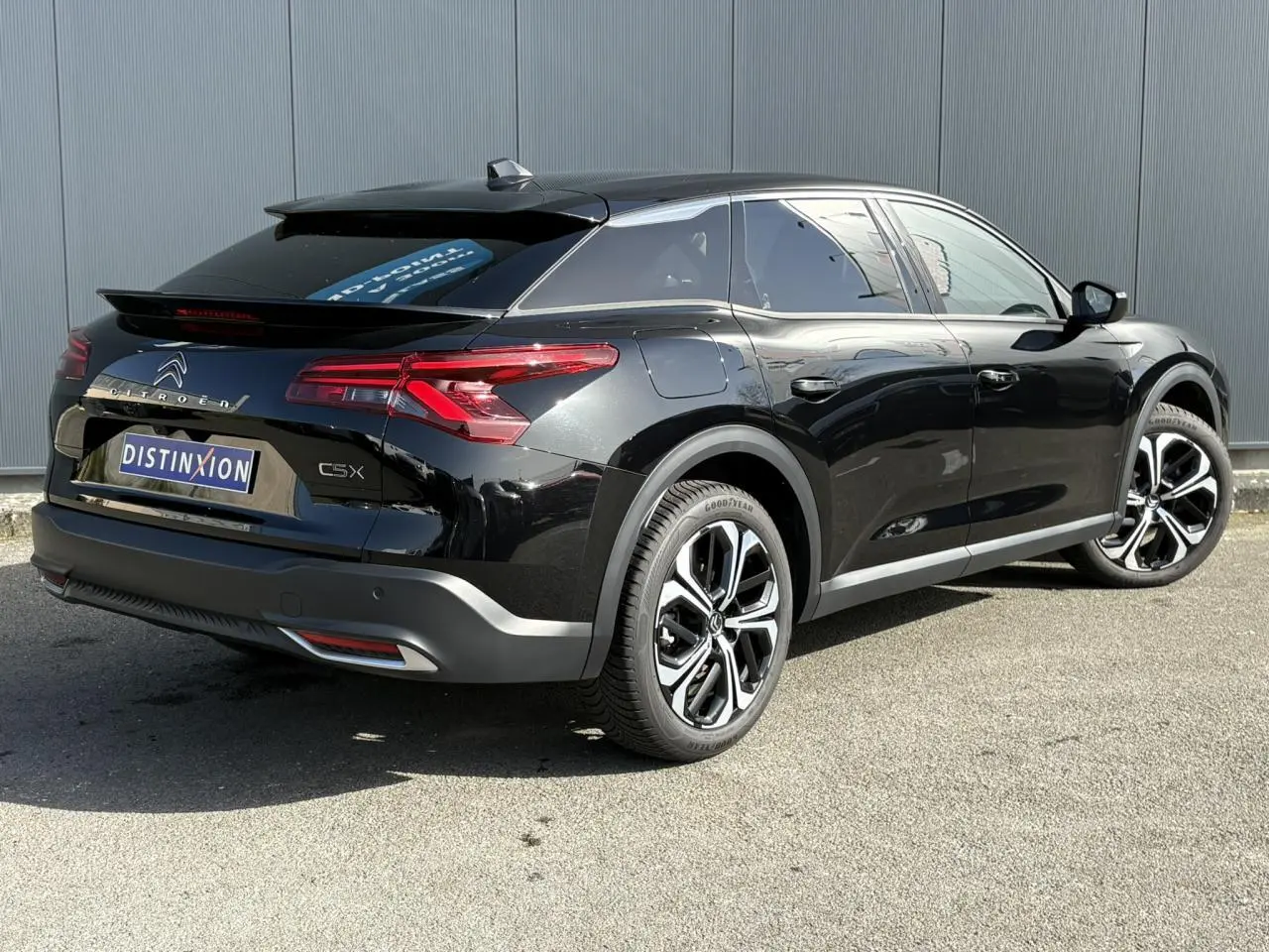 Vue 3/4 arrière droite d'une Citroën C5 X noir Perla avec jantes alliage 19'' et feux arrière LED 3D distinctifs.