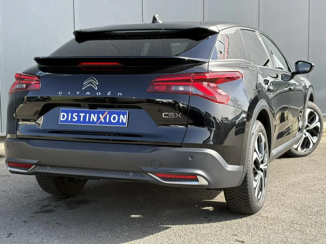 Vue 3/4 arrière droite du Citroën C5 X noir Perla avec feux arrière LED en V et jantes alliage 19 pouces.