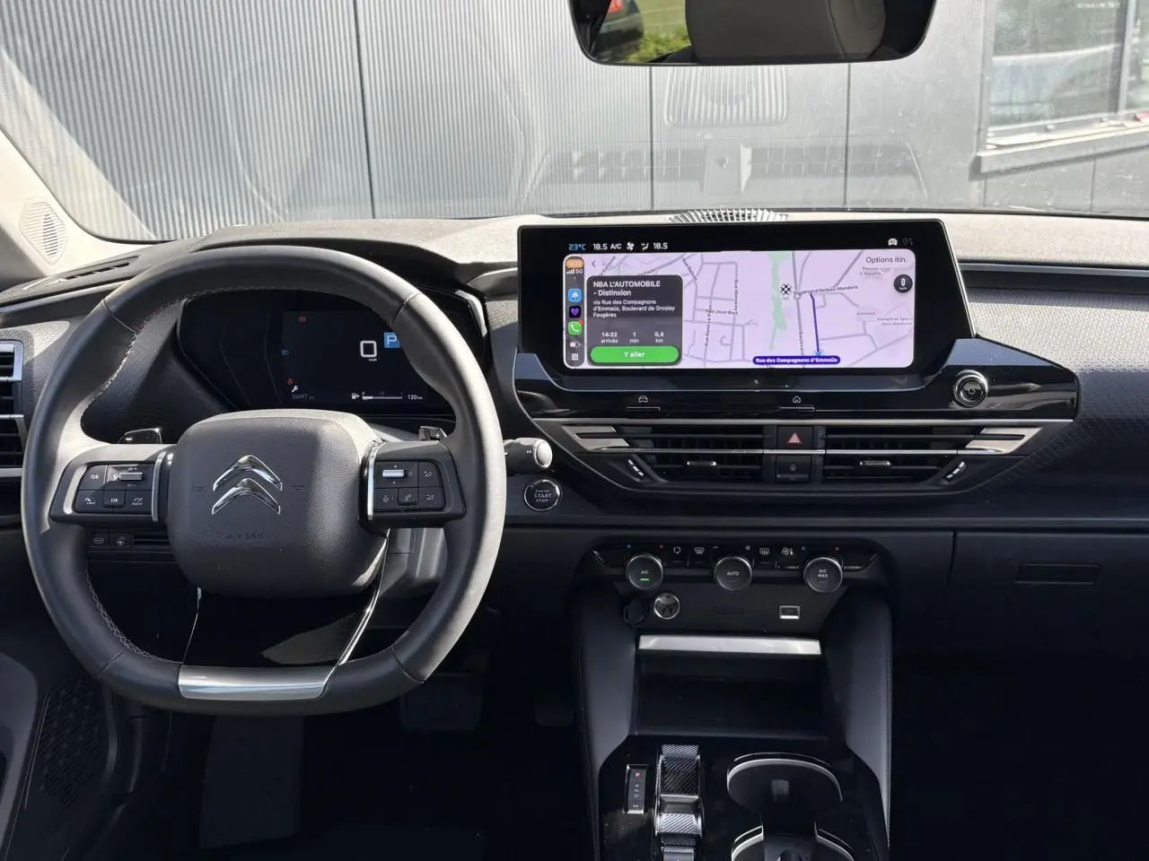 Vue intérieure avant du tableau de bord du Citroën C5 X 2024 avec écran GPS tactile 12 pouces et volant cuir noir.