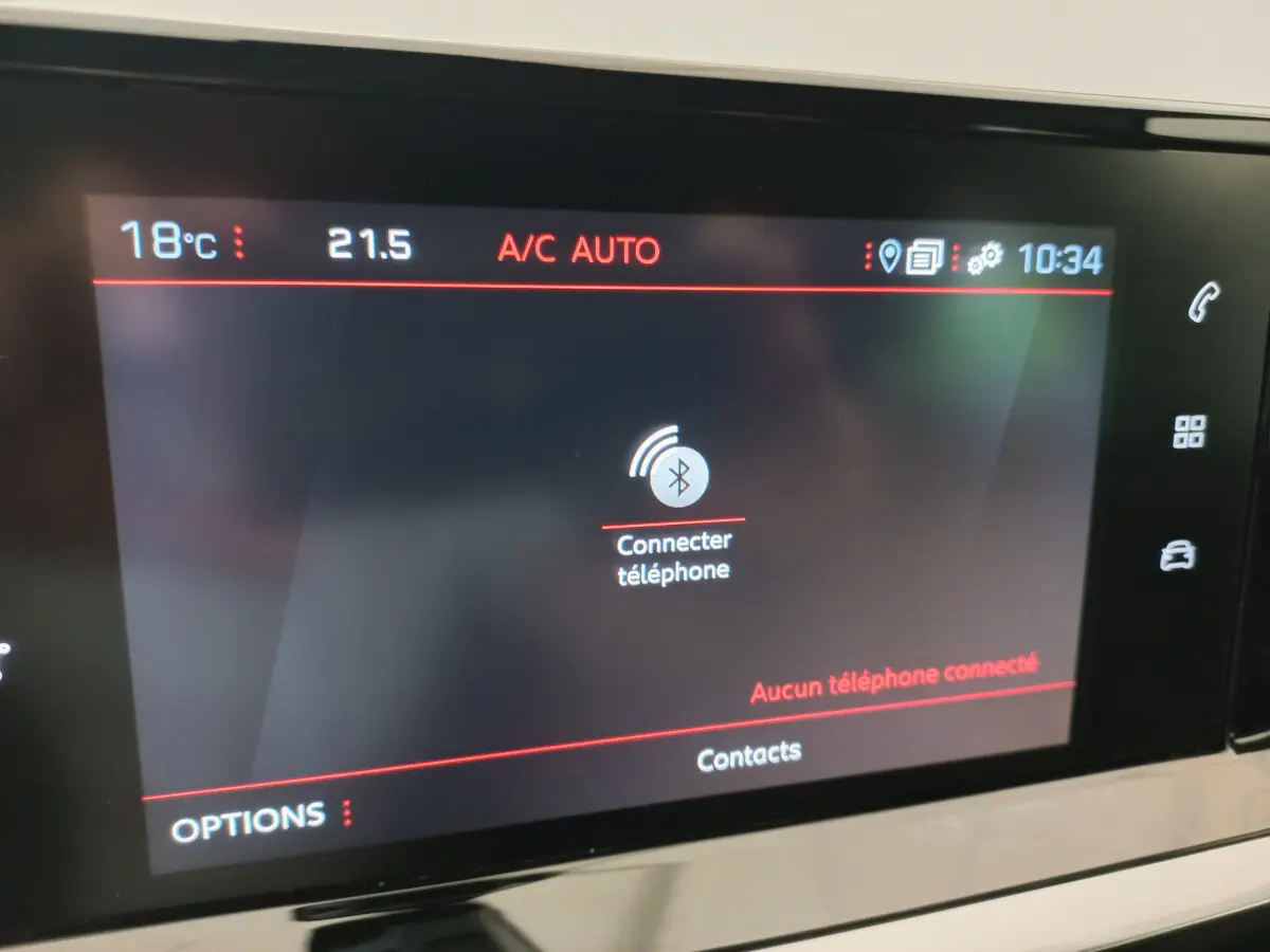 Écran tactile central de la Peugeot 208 PureTech blanc, affichant la connexion Bluetooth pour téléphone.