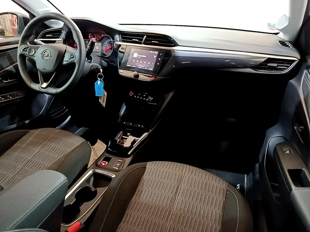 Vue intérieure avant droite de l’Opel Corsa 2023, tableau de bord noir avec écran tactile et volant cuir multifonctions.