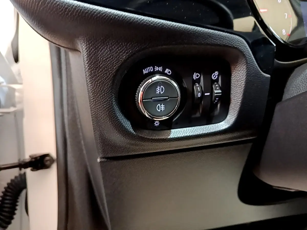 Gros plan sur le panneau de commande des phares à gauche du volant d'une Opel Corsa blanche 2023.