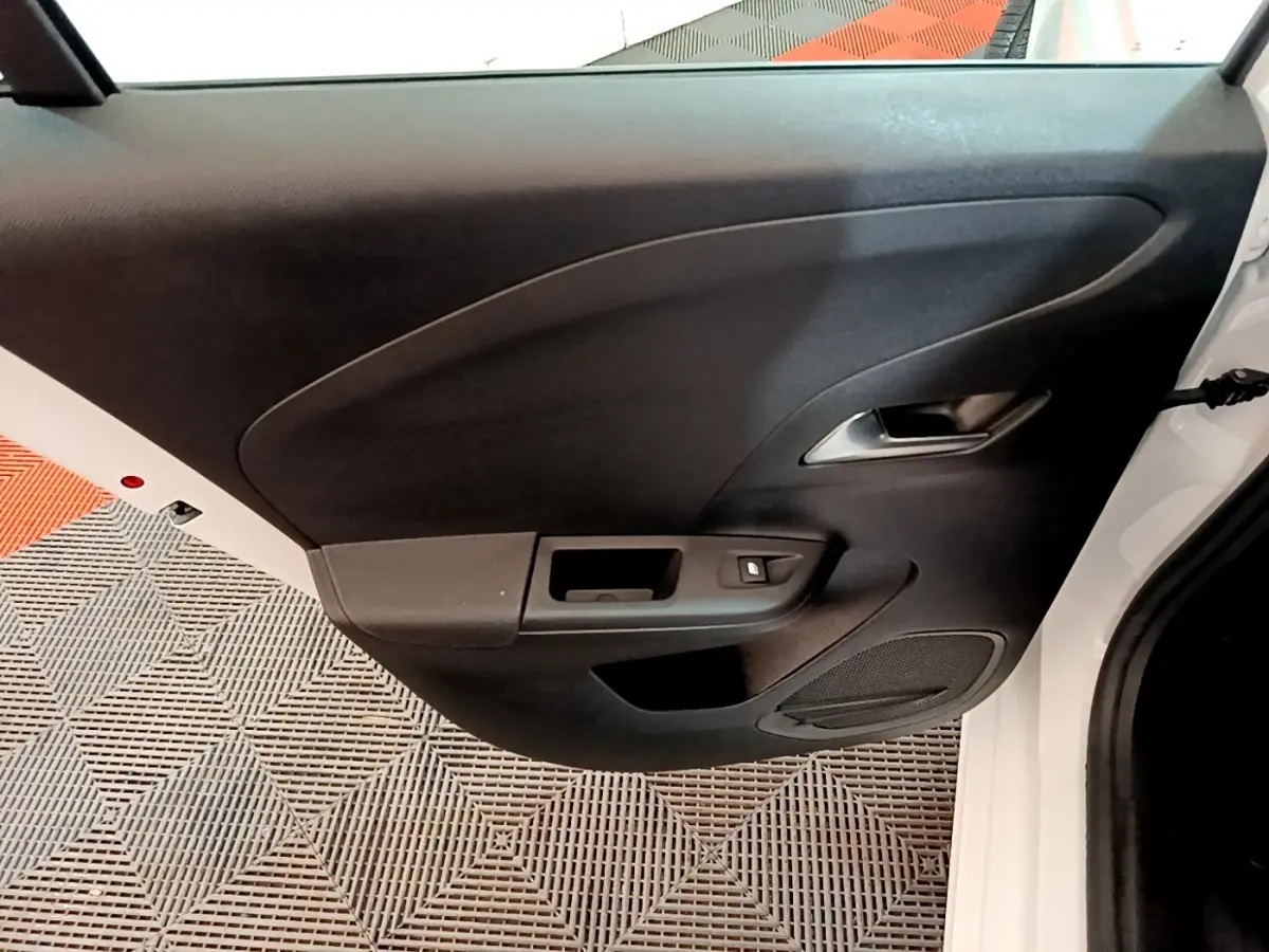 Vue rapprochée de la porte arrière droite noire avec poignée argentée d’une Opel Corsa blanche 2023.