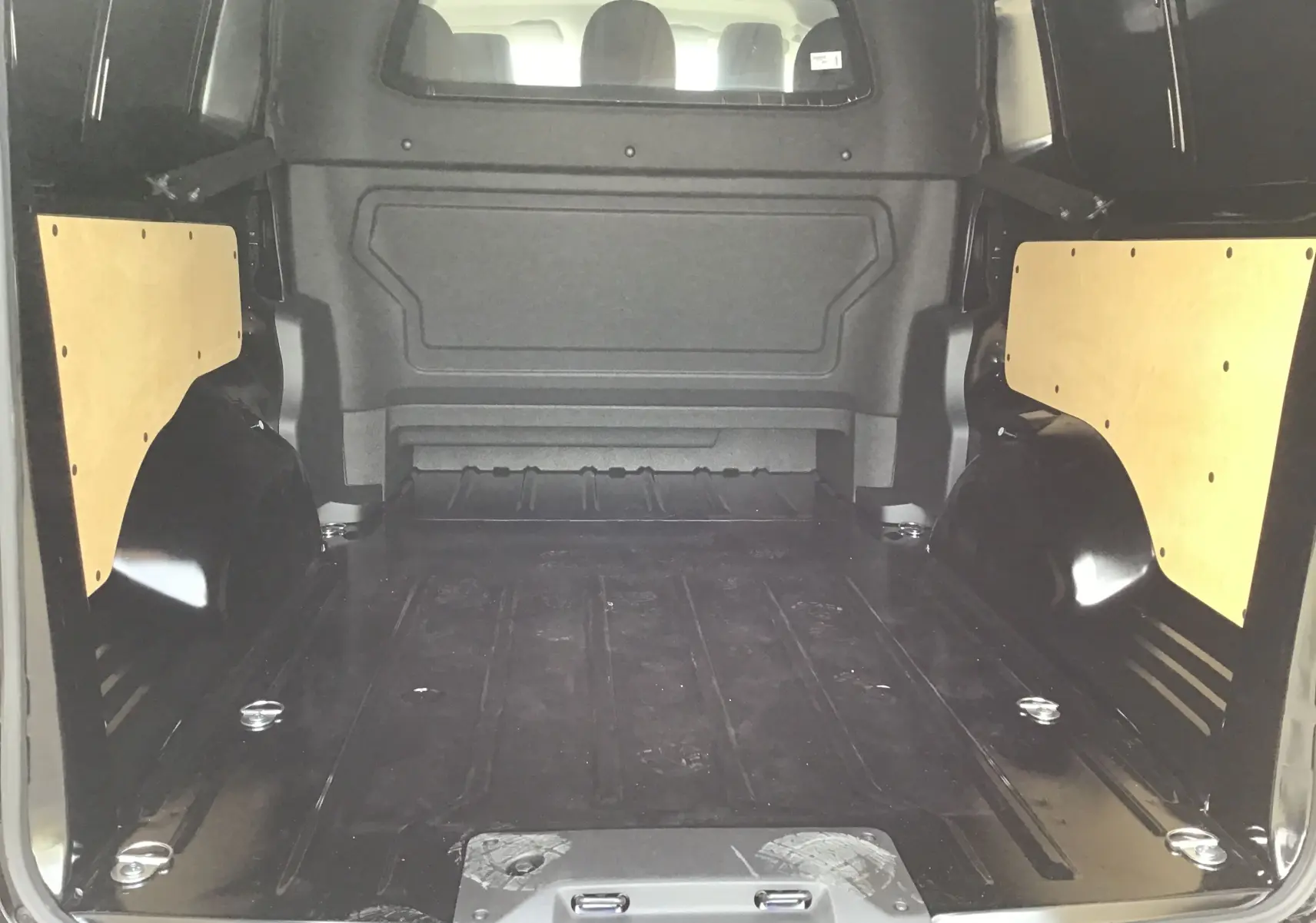 Vue intérieure arrière du Peugeot Expert Cabine Approfondie XL noir, montrant l'espace de chargement avec panneaux latéraux en bois.
