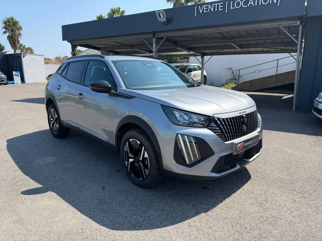 Peugeot 2008 Hybrid 145 gris en 3/4 avant droit, avec calandre noire distinctive et jantes modernes.