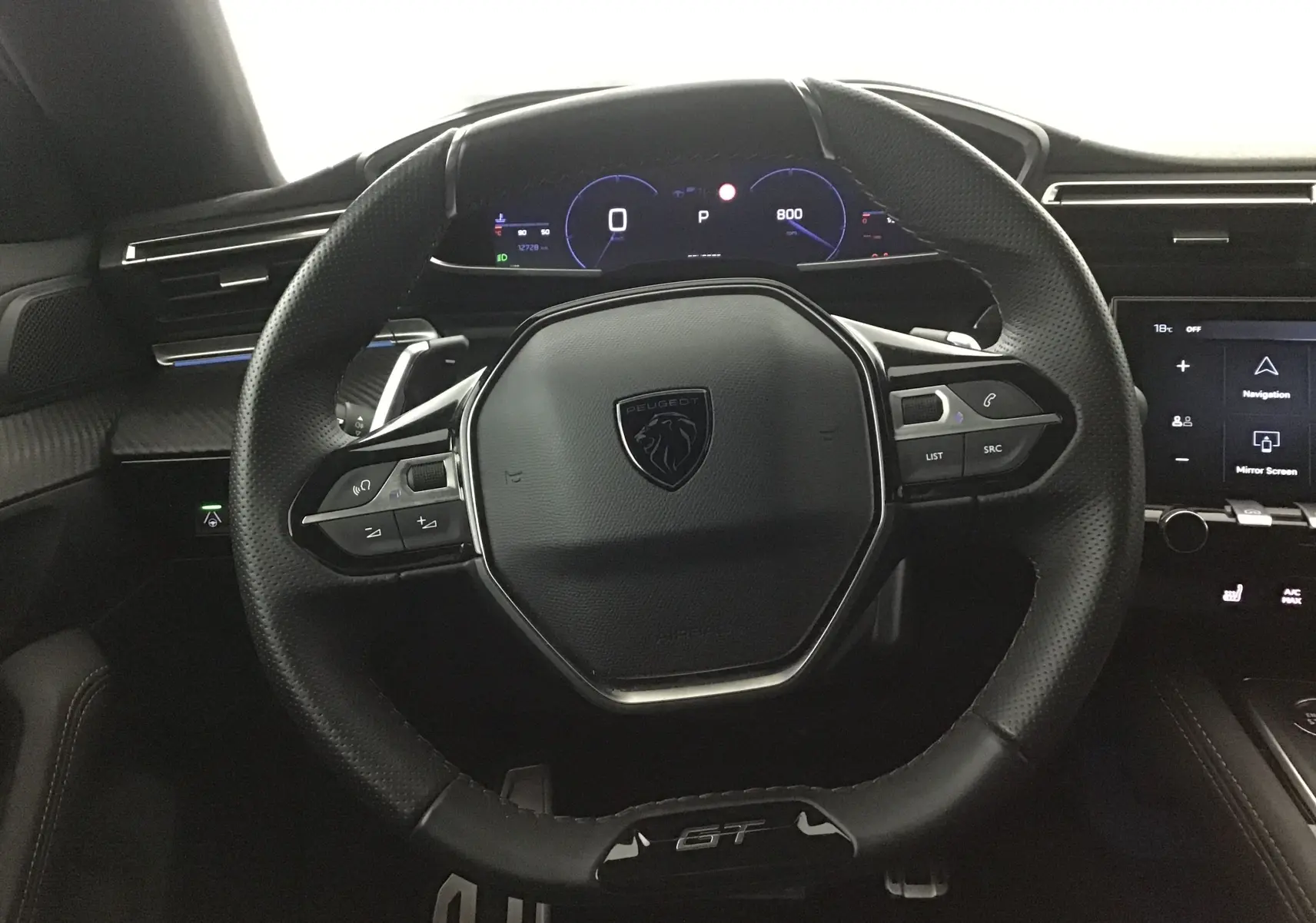 Vue rapprochée du volant cuir noir GT avec commandes intégrées du tableau de bord numérique du Peugeot 508 SW 2024.