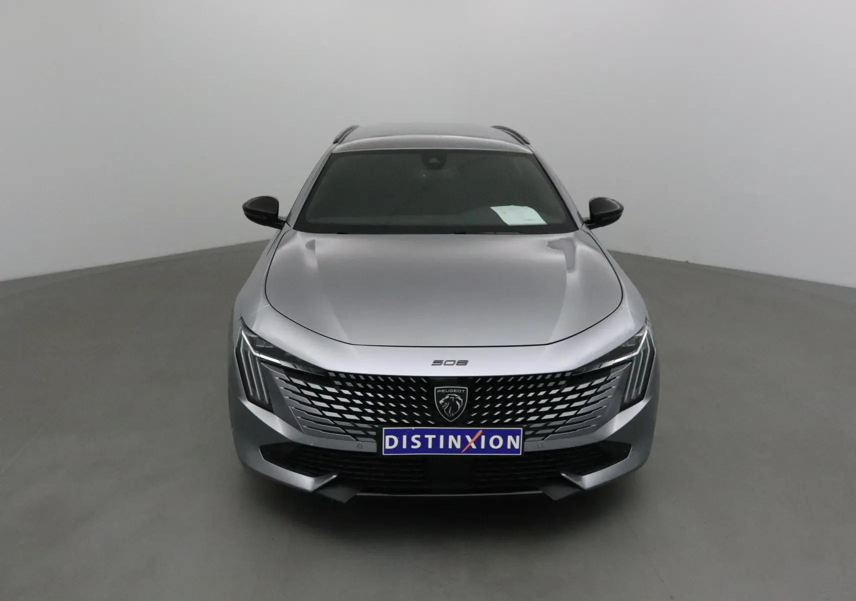 Vue frontale d'une Peugeot 508 SW gris Artense 2024 avec calandre distinctive et phares Full LED.