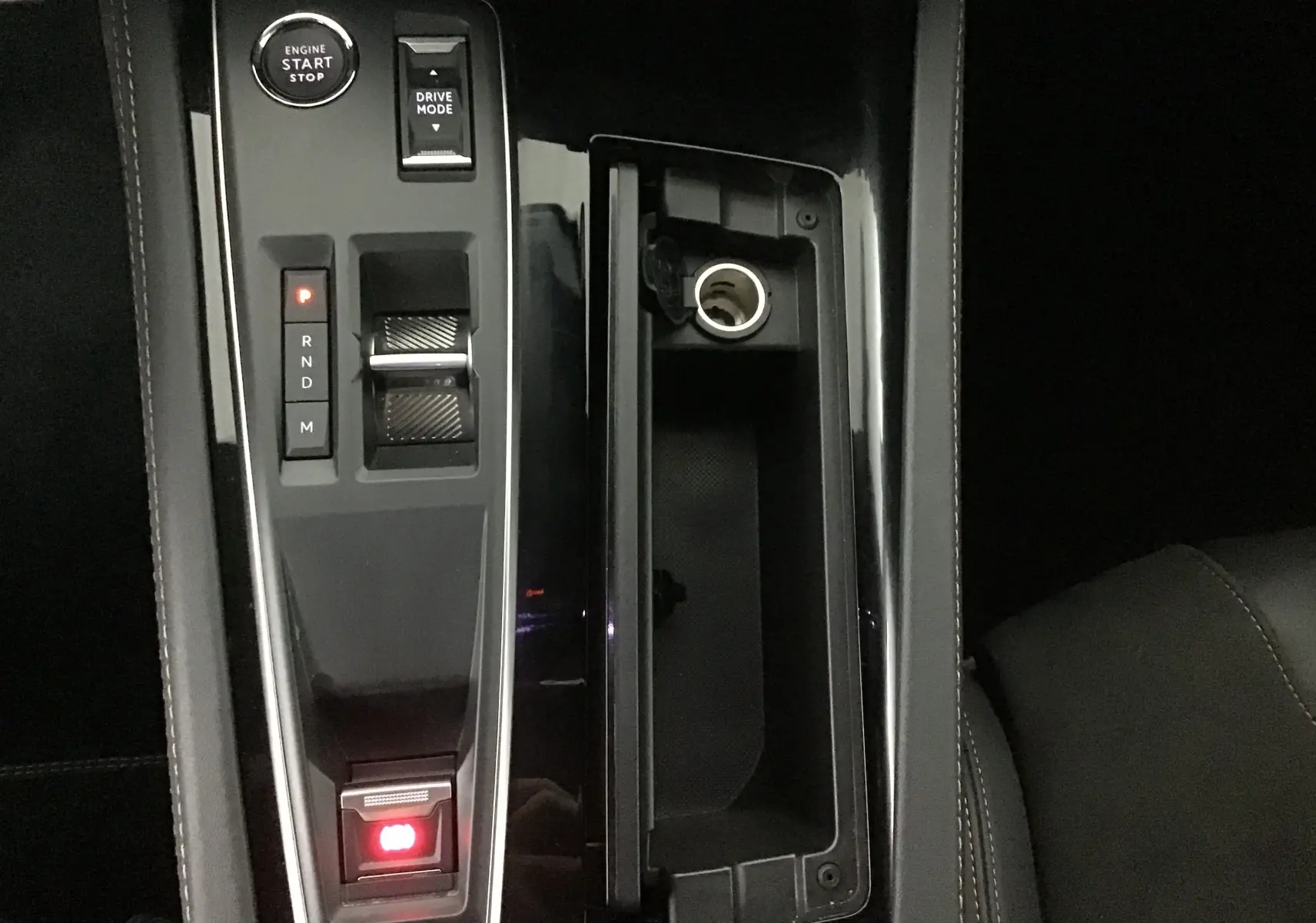 Vue rapprochée de la console centrale noire brillante avec levier de vitesses et bouton start du Peugeot 508 SW gris Artense 2024.