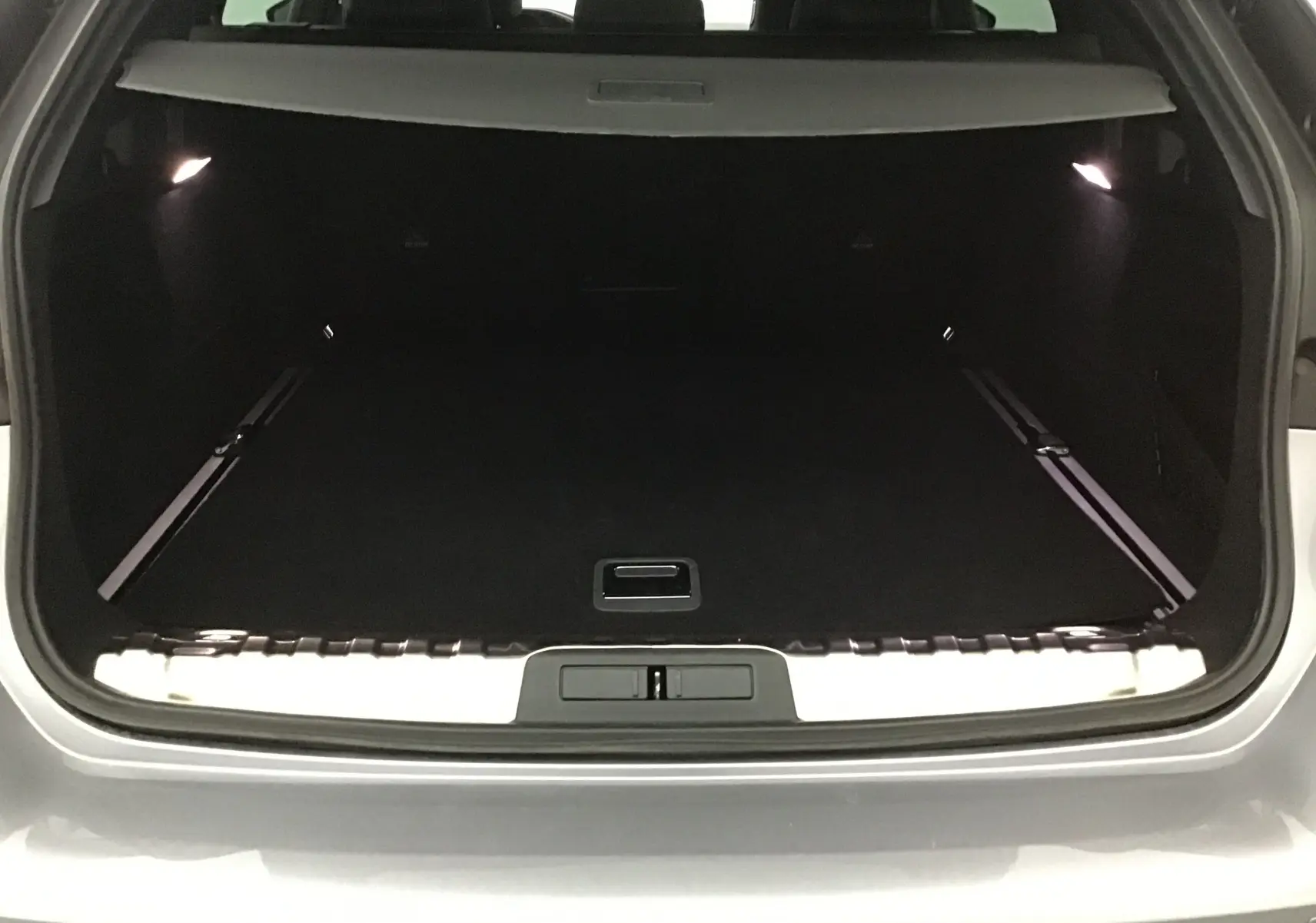 Coffre ouvert d'une Peugeot 508 SW gris Artense, vue arrière montrant l'espace de chargement spacieux et éclairé.
