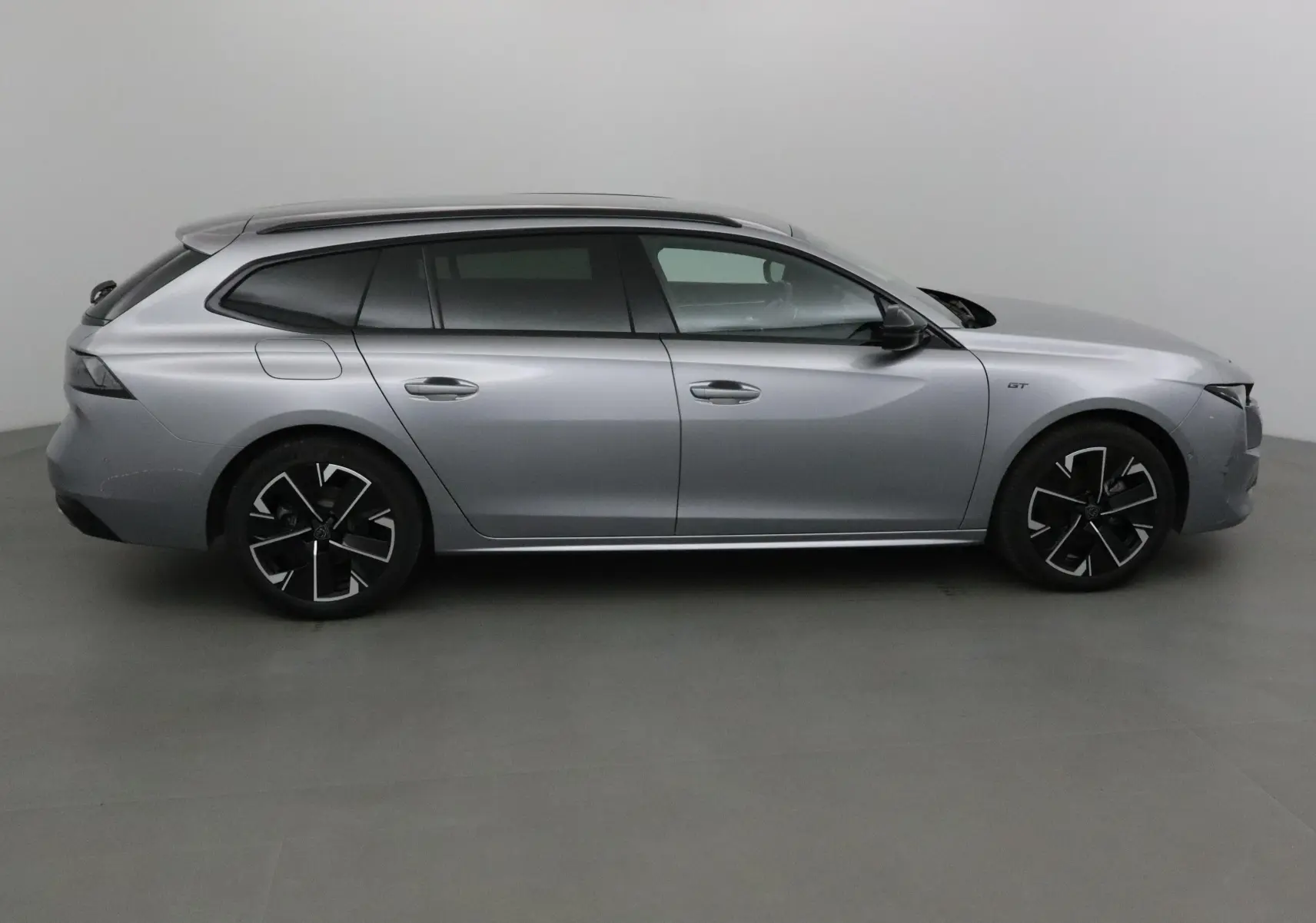 Peugeot 508 SW gris Artense vue de profil côté droit, soulignant ses jantes noires et lignes élégantes.
