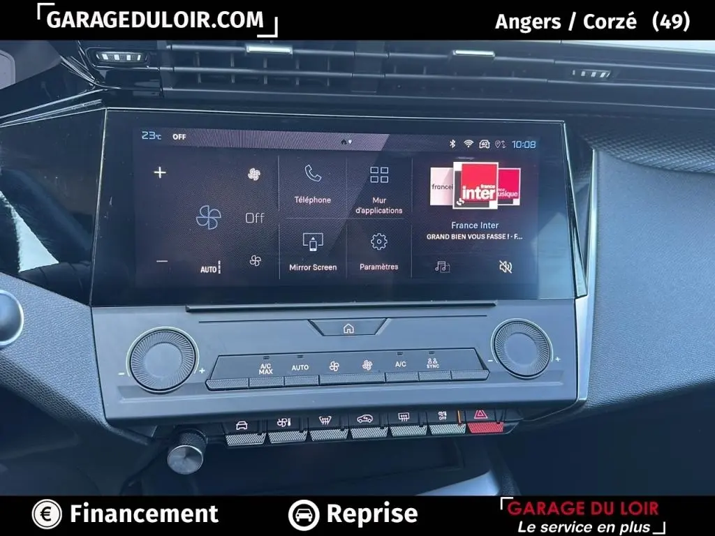 Écran tactile central de la Peugeot 308 gris clair, vue rapprochée du tableau de bord avec commandes climatisation.