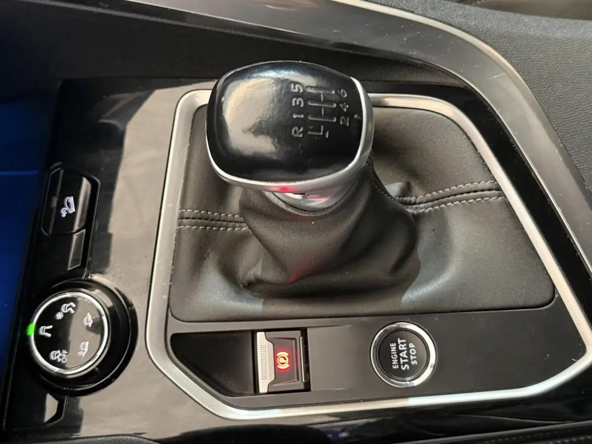 Vue plongeante sur la commande de boîte manuelle noire et le bouton démarrage du Peugeot 3008 vert Puretech 130 S&S Allure.