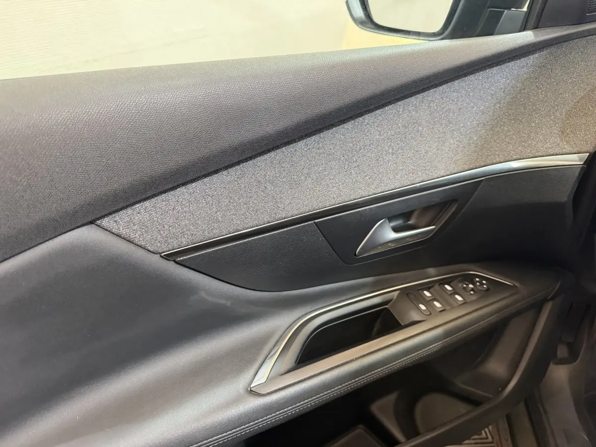Détail de la porte côté conducteur du Peugeot 3008 vert 2020, avec commandes électriques et insert tissu gris.