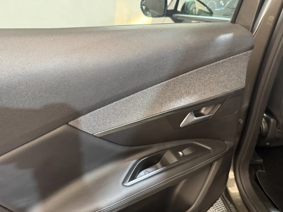 Détail de la porte intérieure côté gauche en cuir et tissu gris du Peugeot 3008 Puretech 130 S&S Allure 2020 vert.