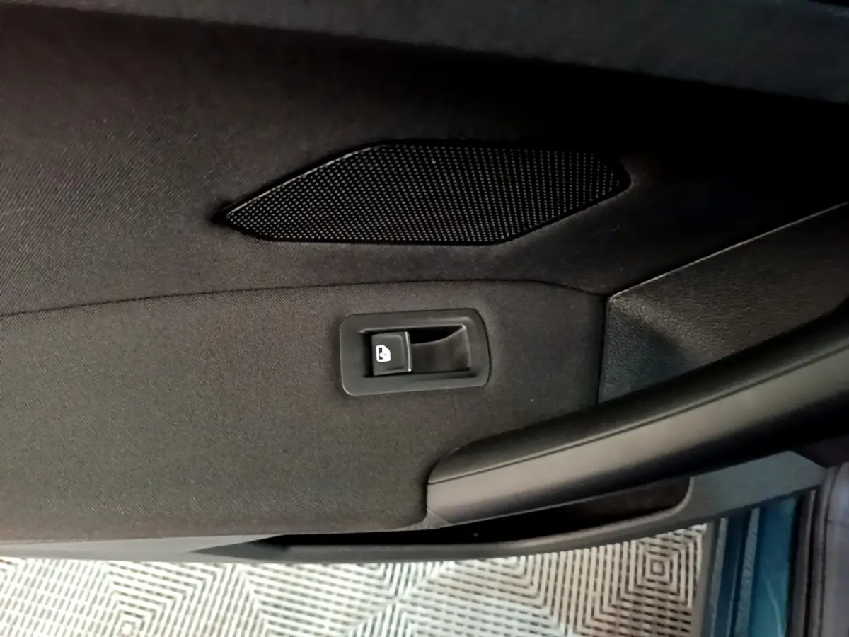 Détail de la poignée intérieure de porte arrière côté droit du Volkswagen Tiguan 1.4 eHybrid bleu.