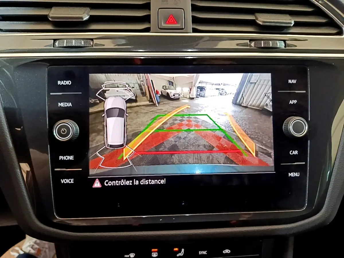 Écran tactile central du Volkswagen Tiguan 1.4 eHybrid montrant la caméra de recul avec guidage de trajectoire coloré.