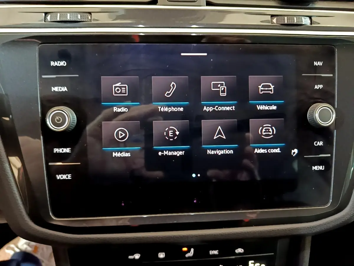 Écran tactile central du Volkswagen Tiguan 1.4 eHybrid 2021 affichant les menus radio, téléphone, navigation et véhicule.