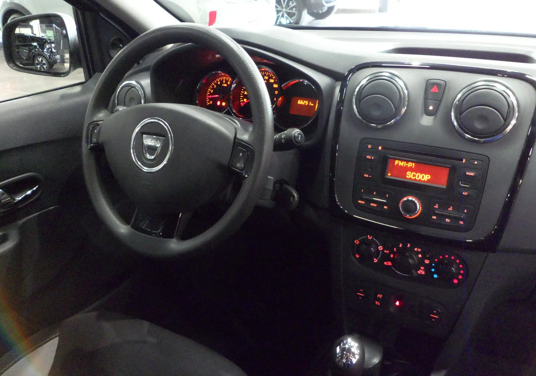 Intérieur de la Dacia Sandero Stepway 2016, vue du poste de conduite côté gauche avec tableau de bord et console centrale noire.