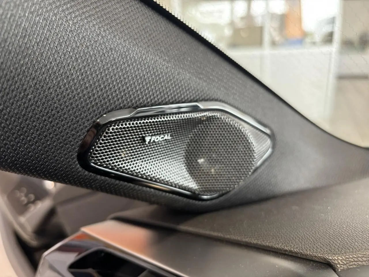 Gros plan sur l'enceinte Focal intégrée dans l'habillage noir du tableau de bord d'une Peugeot 308 2024.