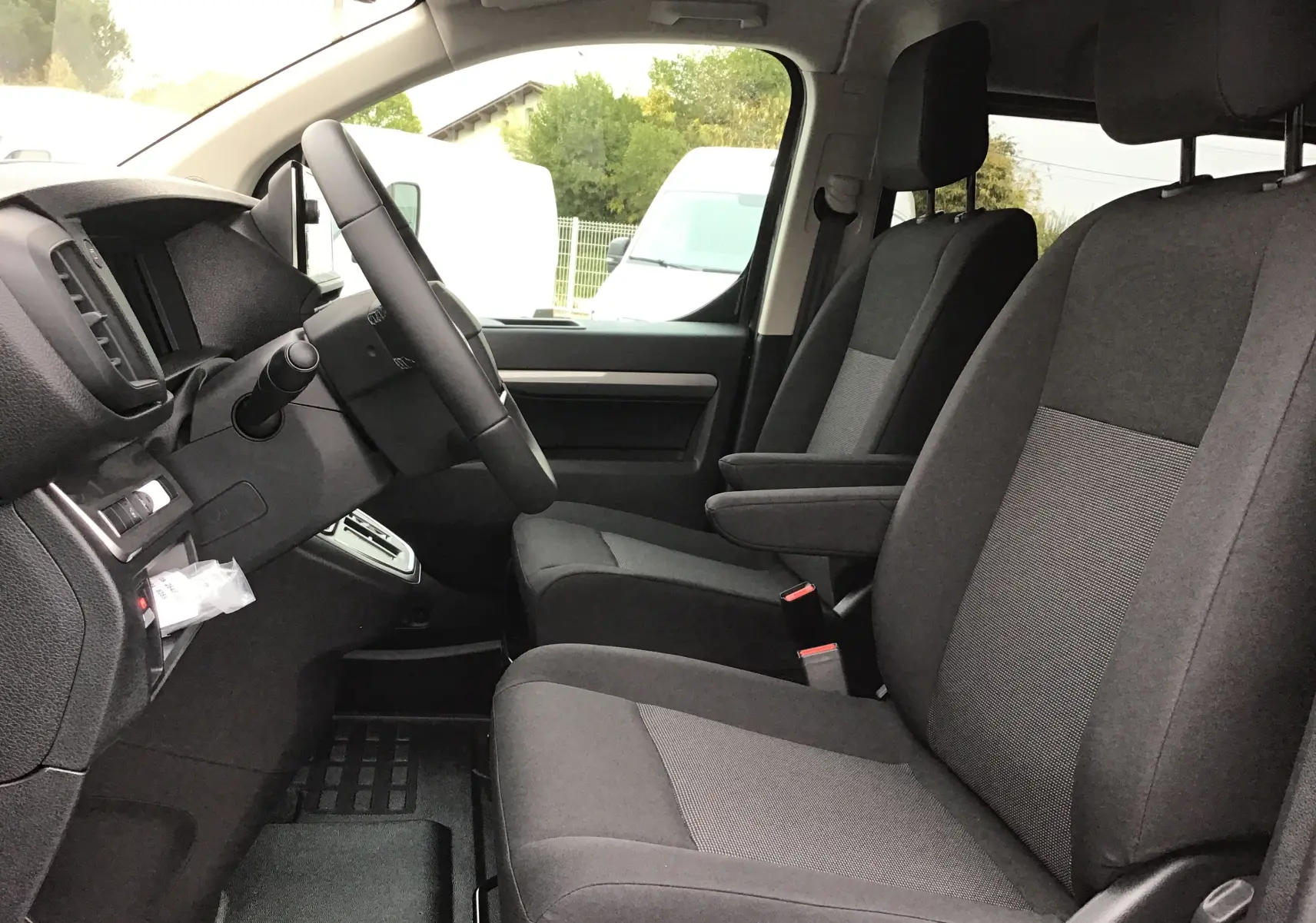 Vue intérieure côté conducteur du Peugeot Expert Cabine Approfondie XL, sièges tissu gris et tableau de bord noir.
