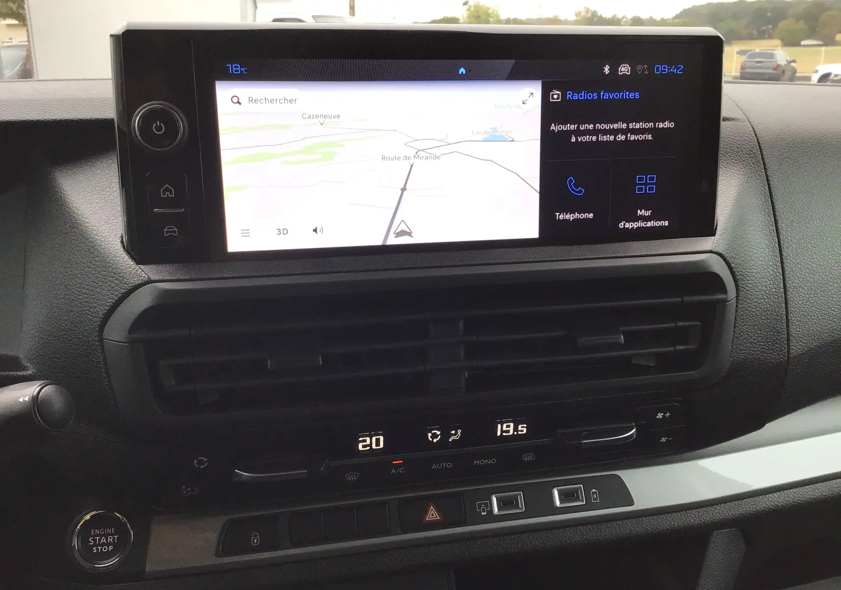Vue rapprochée de l’écran tactile central et de la console du Peugeot Expert gris titane, avec commandes climatisation et bouton start/stop visibles.