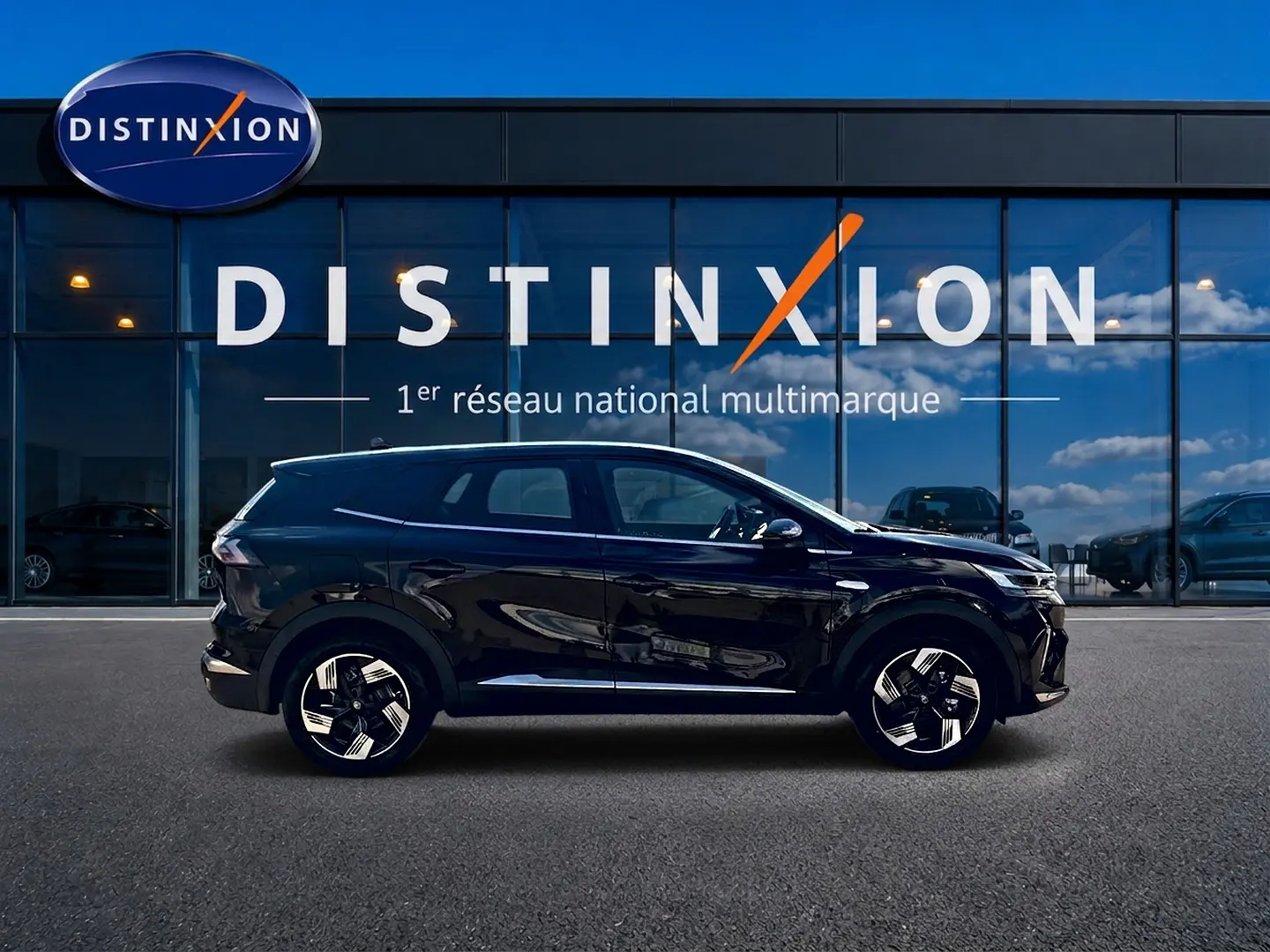 Profil droit d’un Renault Symbioz noir étoile, SUV hybride 2026, avec jantes alu distinctives, devant une vitrine Distinxion.