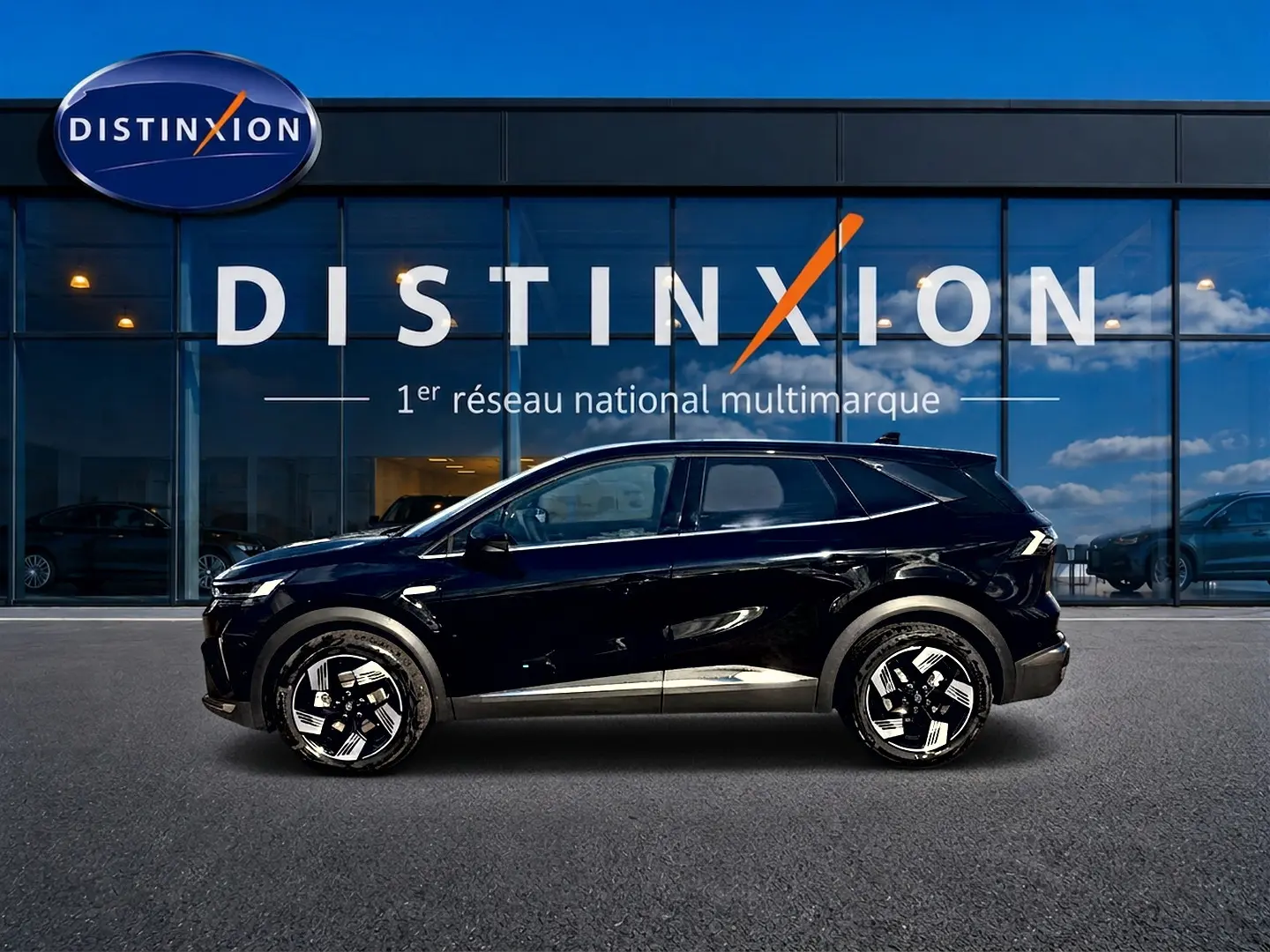 Profil droit d’un Renault Symbioz noir étoile 2026, SUV hybride avec jantes alu au design moderne, devant une vitrine Distinxion.