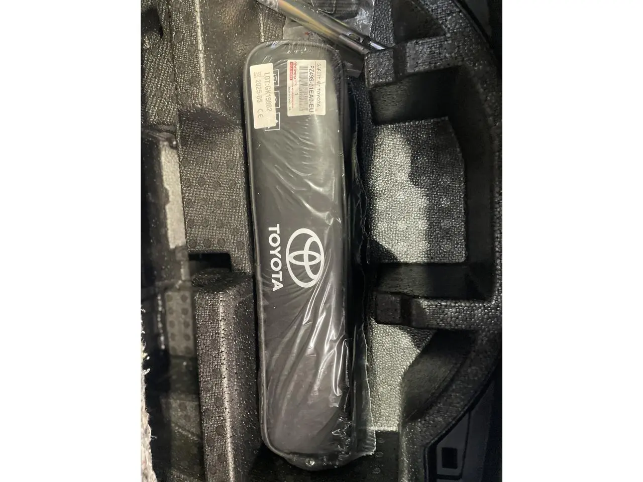 Gros plan sur un kit de sécurité Toyota noir dans un compartiment en mousse, accessoire d'origine Toyota visible.