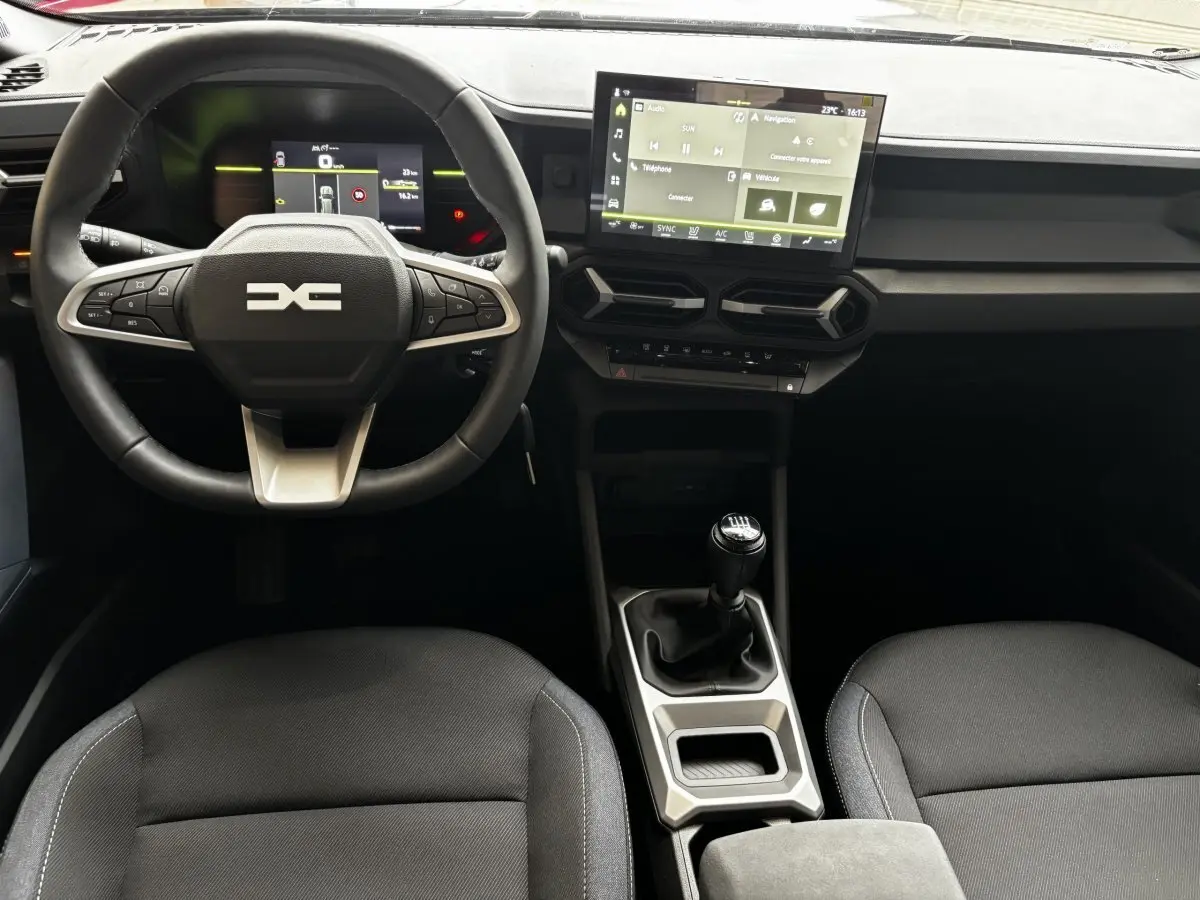 Vue intérieure du tableau de bord et volant cuir du Dacia Bigster 2025 avec écran tactile et boîte manuelle.