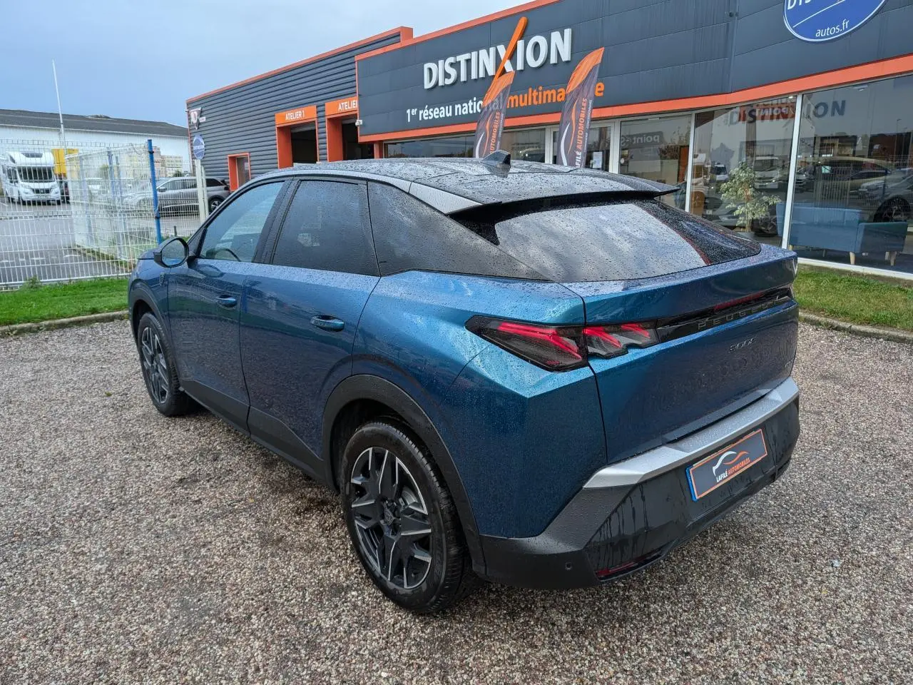 Vue 3/4 arrière droite d’un Peugeot 3008 GT hybride bleu métallisé avec toit noir et feux arrière à griffes LED.