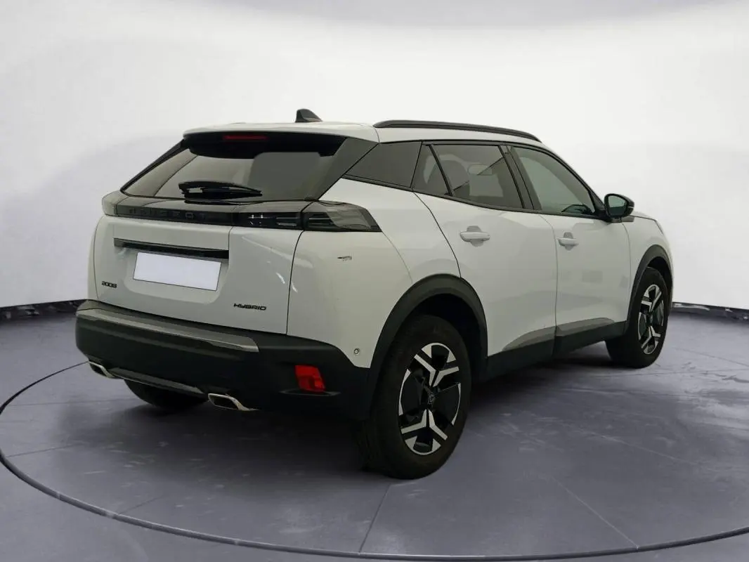 Peugeot 2008 Hybrid blanc en 3/4 arrière droit, avec jantes alliage 17 pouces et barres de toit noires.