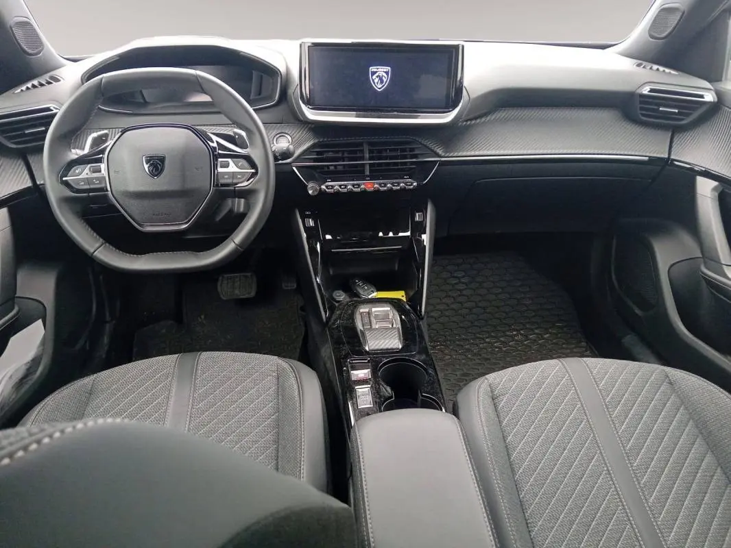 Vue intérieure avant du Peugeot 2008 Hybrid 136 e-DCS6 Allure avec tableau de bord noir et écran tactile central.