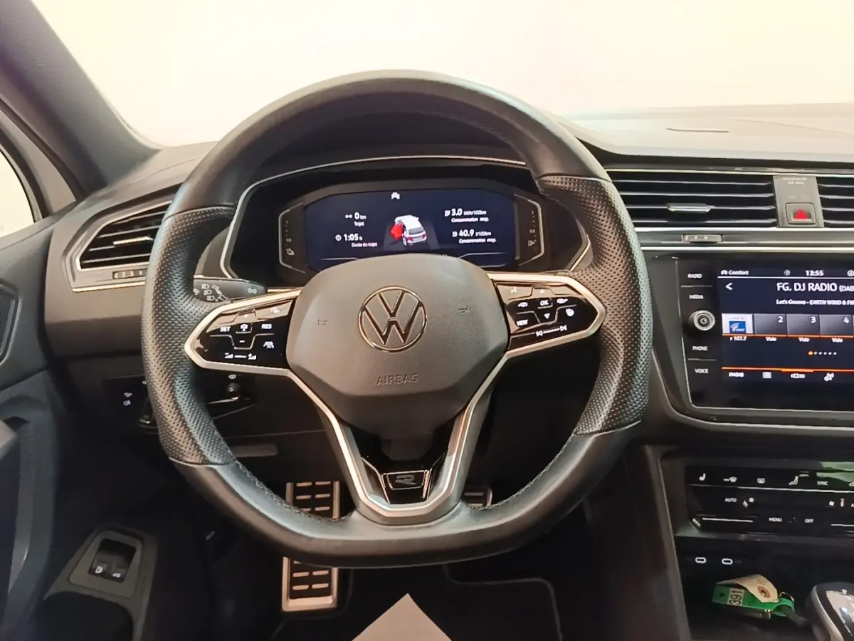 Vue intérieure centrée sur le volant cuir multifonctions et le tableau de bord digital du Volkswagen Tiguan blanc 2023.