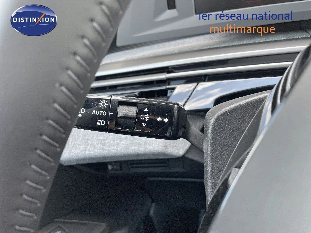 Gros plan sur la commande des phares et clignotants à gauche du volant du Peugeot 3008 Hybrid bleu Ingaro Metal, intérieur moderne.