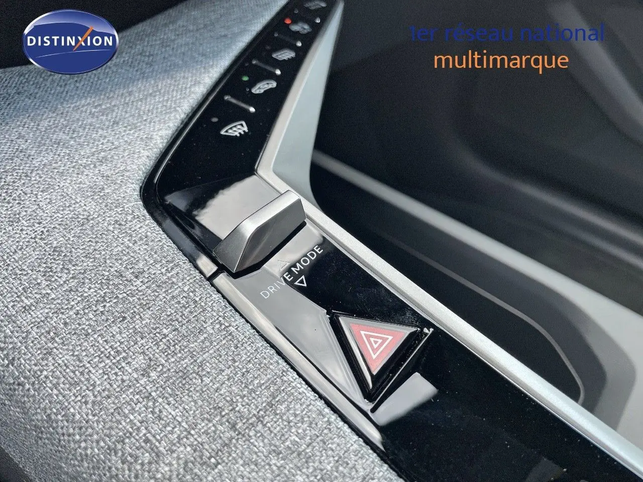 Gros plan sur la console centrale du Peugeot 3008 Hybrid 2025, bouton Drive Mode et signal d'alerte sur surface noire brillante.