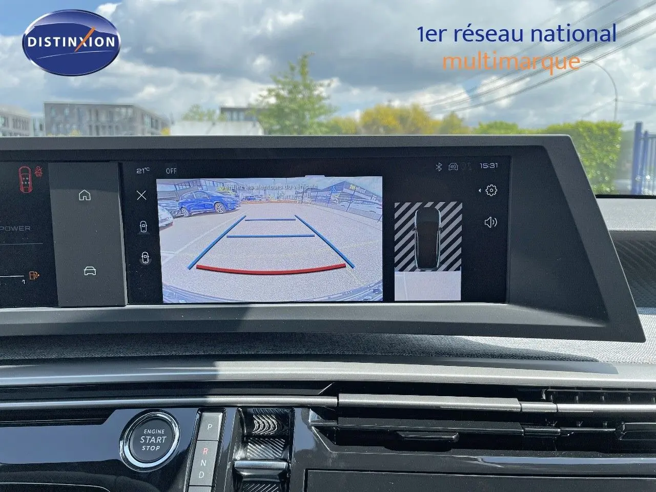 Écran central affichant la caméra de recul du Peugeot 3008 Hybrid bleu Ingaro Metal, avec vue arrière du parking.