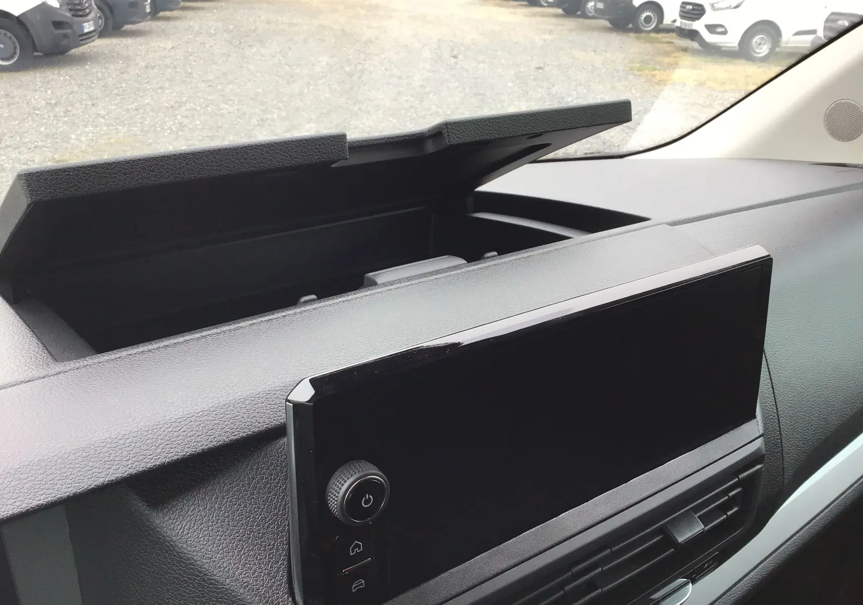 Vue rapprochée de la console centrale du Peugeot Expert gris titane, avec écran tactile et rangement ouvert.
