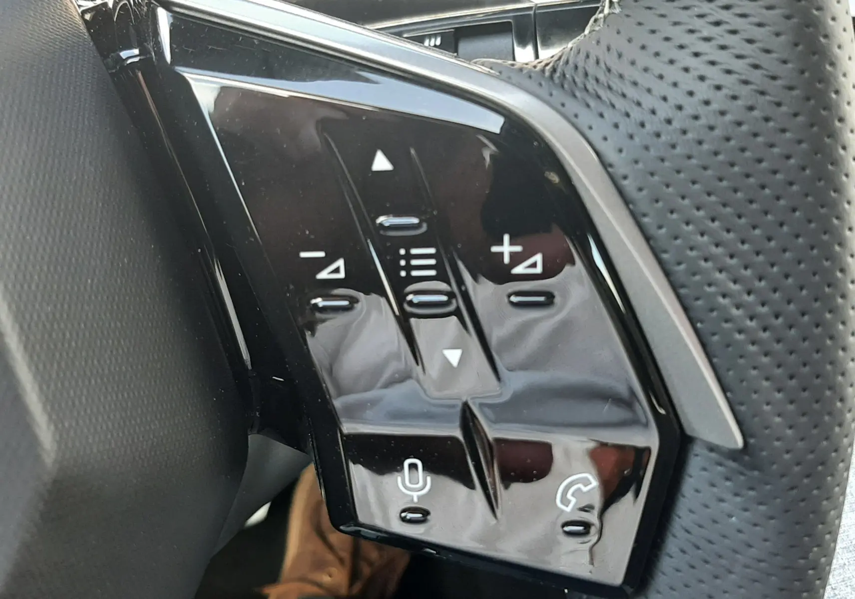 Gros plan sur les commandes du volant côté gauche du Peugeot 3008 Bleu Obsession 2026 avec bouton start/stop visible.