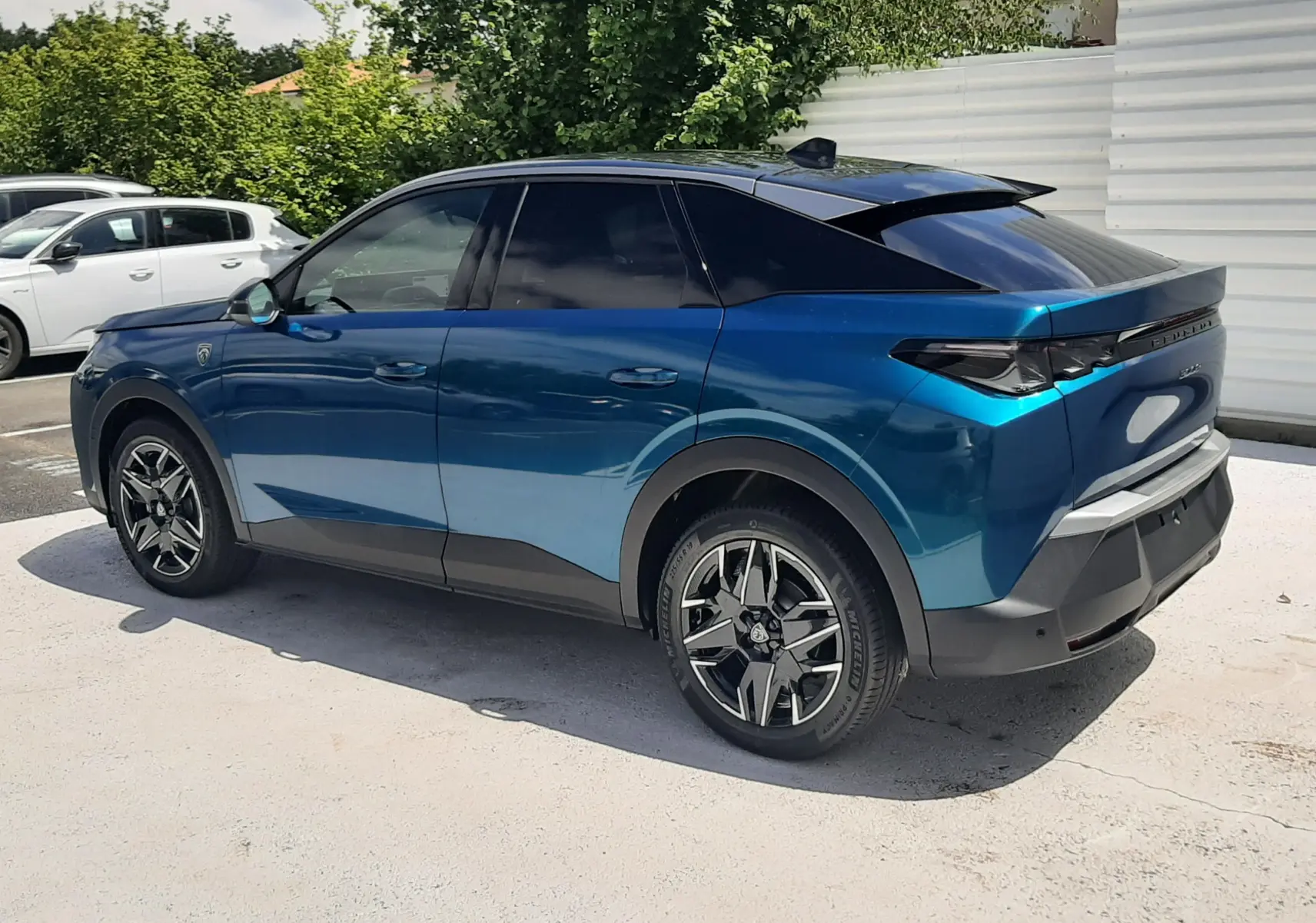 Peugeot 3008 1.2 Hybrid 145ch GT bleu obsession vue de profil côté gauche, toit noir et jantes distinctives.