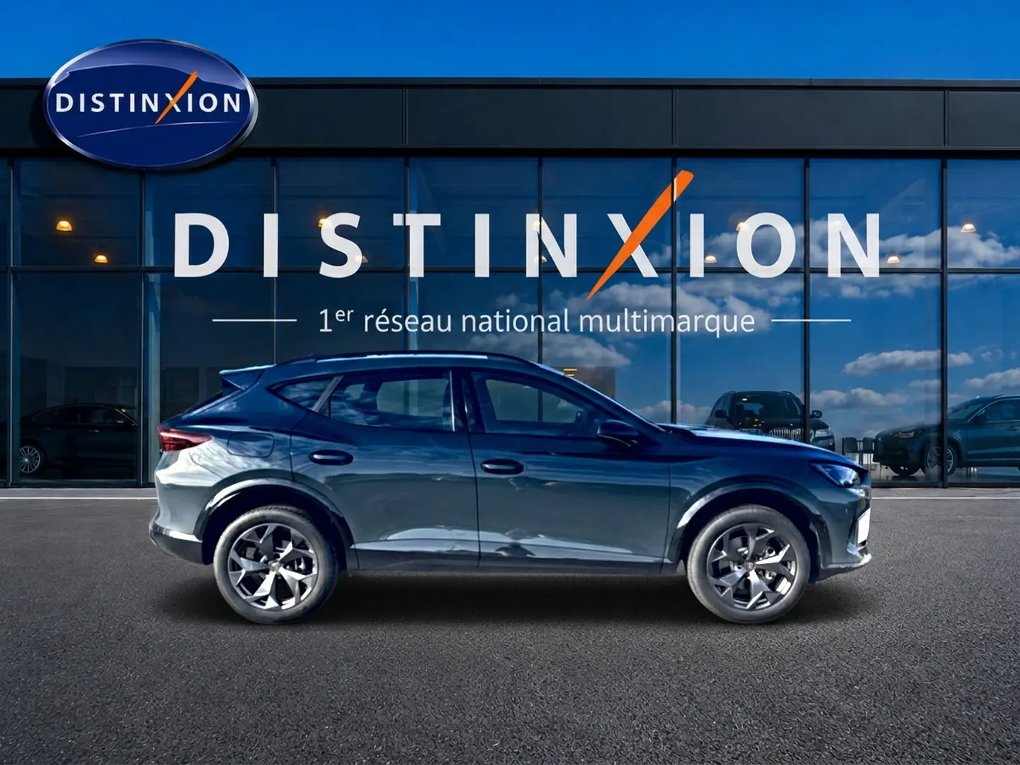 Profil côté gauche d'un CUPRA Formentor 1.5 etsi hybrid bleu fjord avec jantes 18 pouces, devant une vitrine Distinxion.