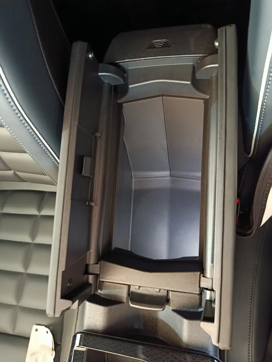 Vue plongeante sur le rangement central ouvert avec intérieur noir et sellerie cuir noir sur Citroën C5 Hybride 2026.