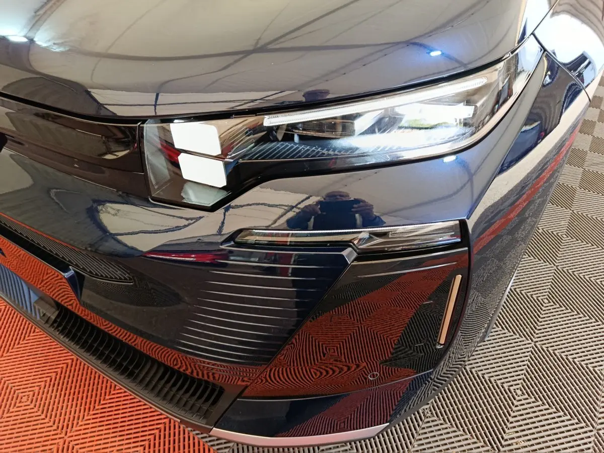 Gros plan sur le phare avant droit bleu foncé du Citroën C5 Hybride 2026 avec détails du pare-chocs et éclairage LED.