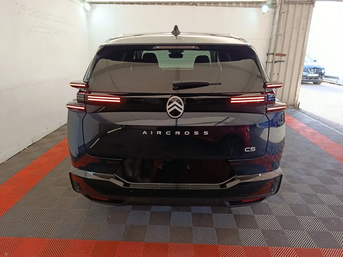 Vue arrière d'un Citroën C5 Aircross bleu avec feux LED horizontaux allumés dans un garage.