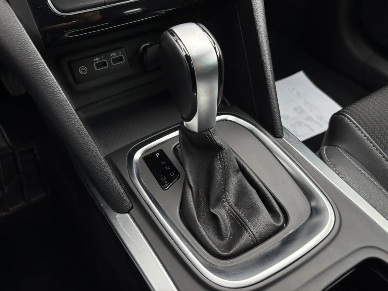 Le levier de vitesses automatique en cuir et métal de la Renault Mégane Break 2024, vue rapprochée de la console centrale.