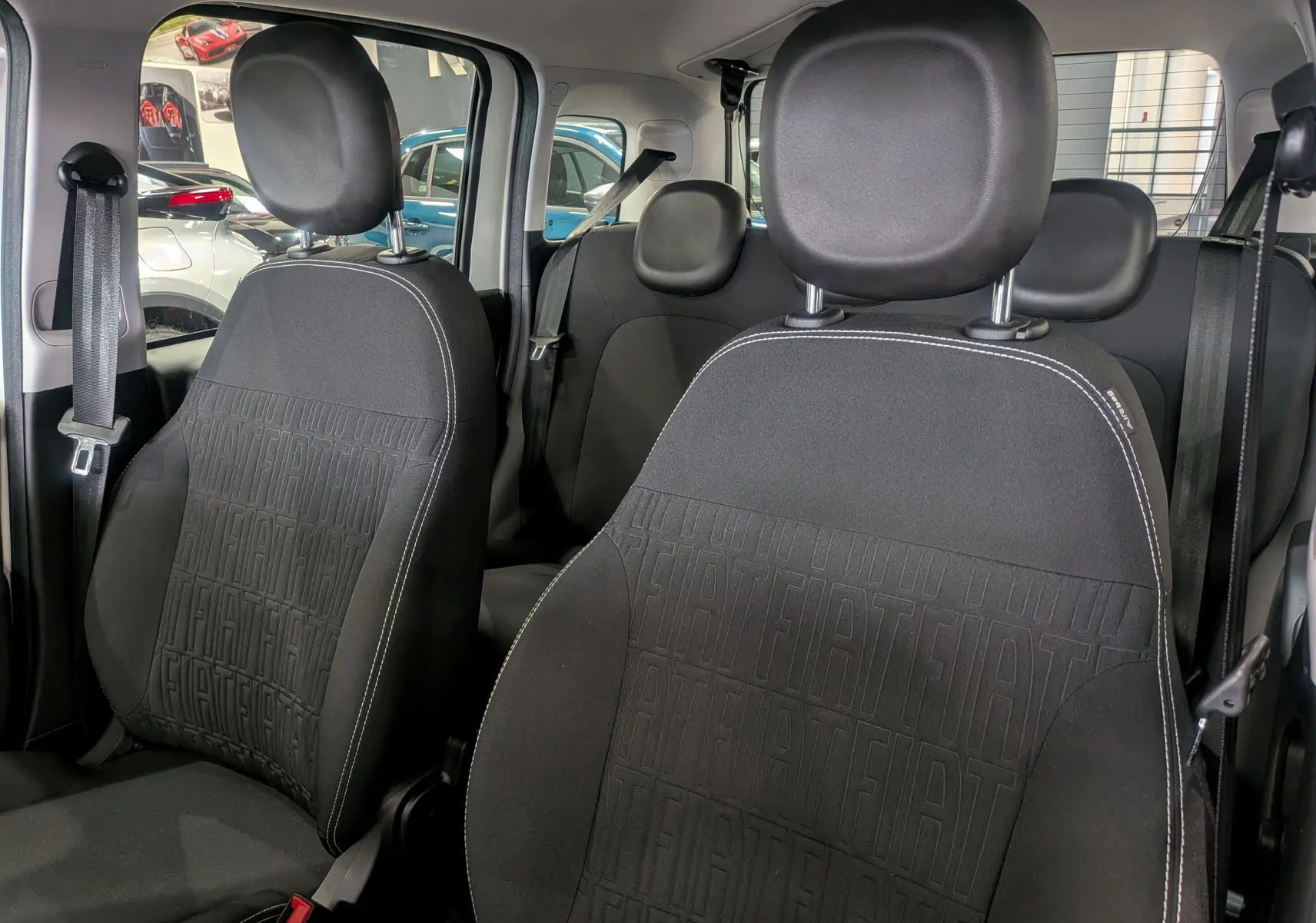 Gros plan sur les sièges avant en tissu noir avec motif FIAT embossé de la Fiat Panda 1.0 Hybrid City 2025.