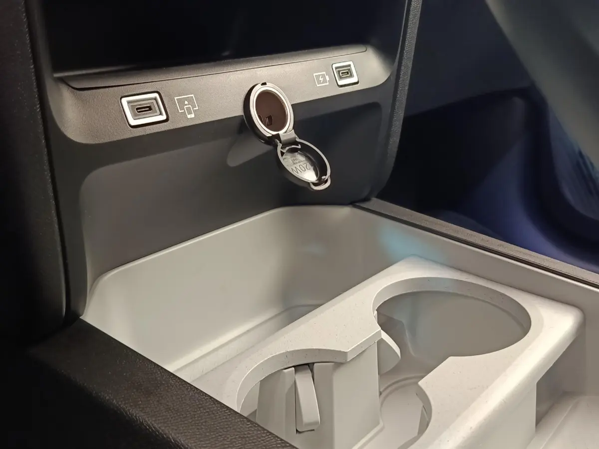 Gros plan sur la console centrale intérieure de la Citroën C5 hybride avec ports USB et prise 12V ouverte, finition claire.