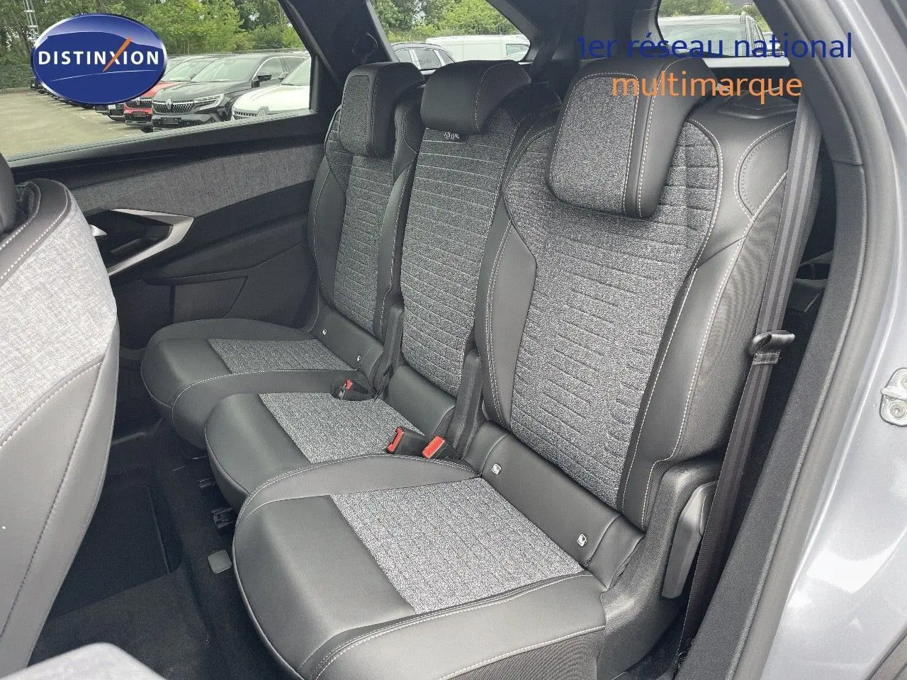 Vue intérieure sur les sièges arrière en tissu gris et cuir noir du Peugeot 5008 Hybrid 136ch 2025, porte ouverte côté droit.