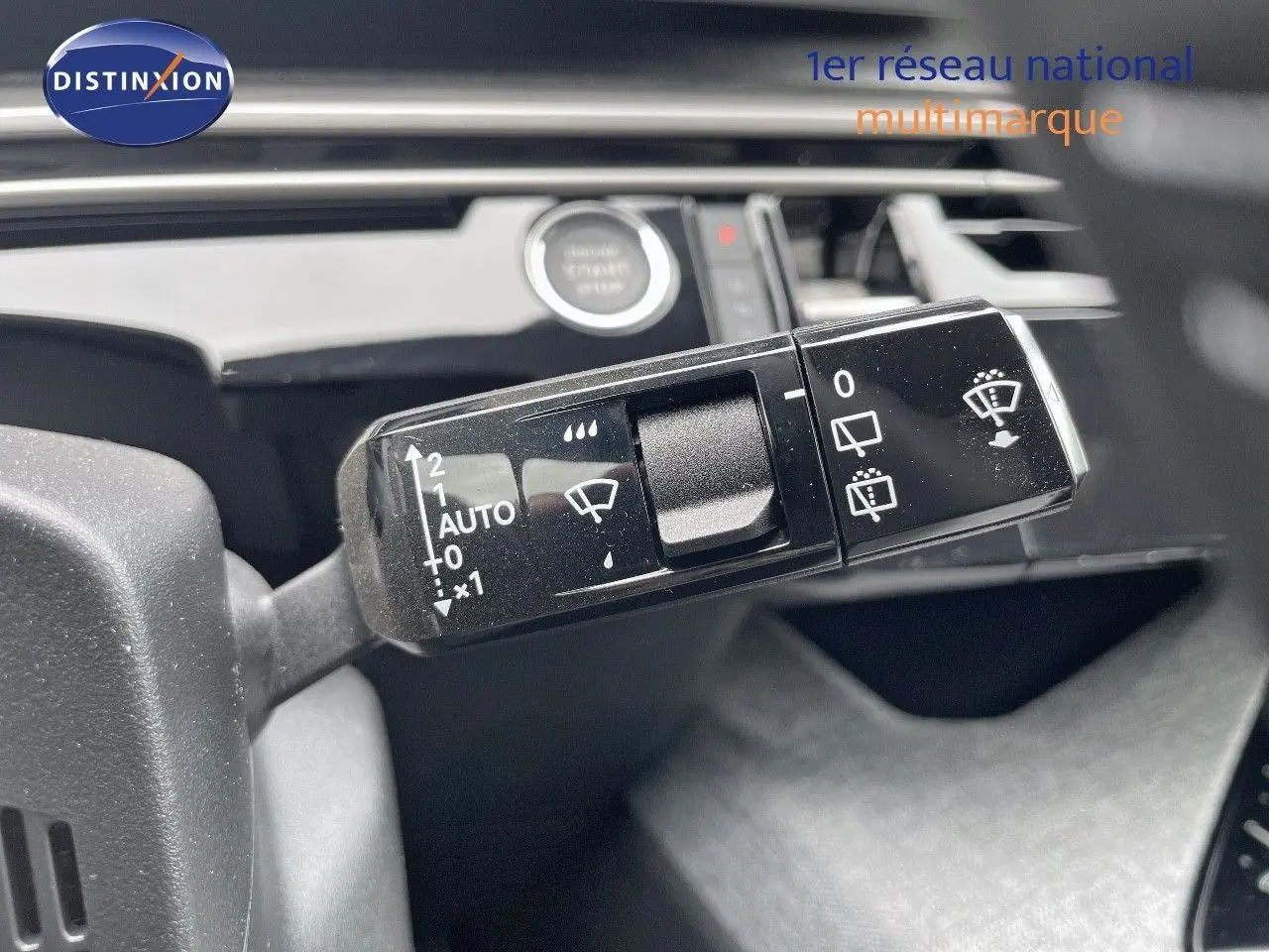 Gros plan sur la commande des essuie-glaces du Peugeot 5008 gris Artense, intérieur noir avec bouton start visible.